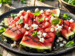 Fette di anguria alla brace grigliate con feta sbriciolata e menta fresca