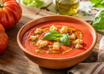 ricetta-gazpacho-all-italiana-zuppa-fredda-pomodoro Una ciotola di gazpacho all'italiana guarnita con crostini di pane e un filo d'olio d'oliva