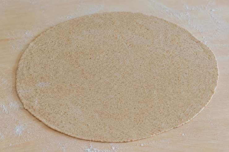 Trascorso il tempo di riposo, dividete il panetto in 4 parti uguali (circa 100g l’una) e formate delle palline. Con l’aiuto di un mattarello, stendete ogni pallina sulla spianatoia leggermente infarinata fino ad ottenere un disco sottile di circa 2 millimetri di spessore. Scaldate molto bene una piastra antiaderente e cuocete una piadina alla volta a fuoco medio alto per circa 2 minuti sul primo lato: quando iniziano a formarsi le tipiche bollicine scure, giratela e cuocetela per un altro minuto sull’altro lato.
