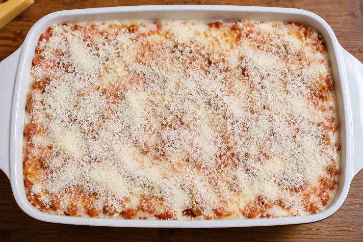 Cospargete lo strato di lasagne all’uovo con un altro mestolo di besciamella e altri quattro cinque cucchiai di ragù. Spolverizzate il tutto con del Parmigiano Reggiano grattugiato e proseguite in questo modo, alternando lasagne, besciamella, ragù e Parmigiano fino ad esaurimento degli ingredienti.