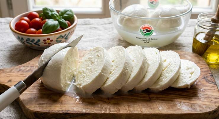 Tagliate la mozzarella di bufala a fette spesse circa 1 cm. Se risulta molto ricca di latte, lasciatela sgocciolare in un colino per circa 10 minuti prima di comporre il piatto, così non rilascerà troppo liquido sul fondo del piatto. Lavate accuratamente i pomodori ed affettateli trasversalmente ottenendo fette dello stesso spessore della mozzarella. Adagiate le fette su un tagliere e salatele leggermente.
