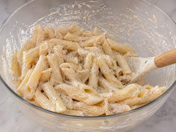 Scolate la pasta al dente e trasferitela direttamente nella ciotola con il condimento. Mantecate la pasta con cura lontano dai fuochi per circa un minuto, aggiungendo se necessario un altro goccio di acqua di cottura per renderla ancora più vellutata. Servite subito se preferite un piatto caldo e avvolgente, oppure riponete la pasta in frigorifero per almeno un’ora se desiderate gustarla fredda e rigenerante.