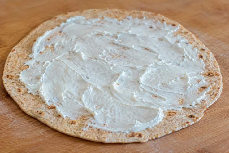 Tenetele in caldo sotto un canovaccio pulito mentre cuocete le altre (l’umidità le manterrà morbidissime). Adagiate ciascuna piadina integrale calda sul proprio piatto da portata, lasciandola completamente aperta. Spalmate subito lo squacquerone fresco sulla superficie, poi distribuite un po’ di rucola fresca e adagiatevi sopra le fette di prosciutto crudo. Lavate delicatamente i fichi freschi, asciugateli, tagliateli e distribuiteli sul prosciutto crudo.