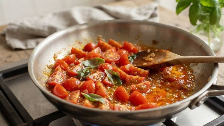 Prendete una padella capiente, versate un abbondante giro di olio extravergine d’oliva e fate soffriggere la cipolla precedentemente tagliata a sottili listarelle. Dopo qualche minuto, aggiungete i pomodorini tagliati nella padella e unite un piccolo pizzico di zucchero, fondamentale per bilanciare e attenuare l’acidità naturale del pomodoro fresco.