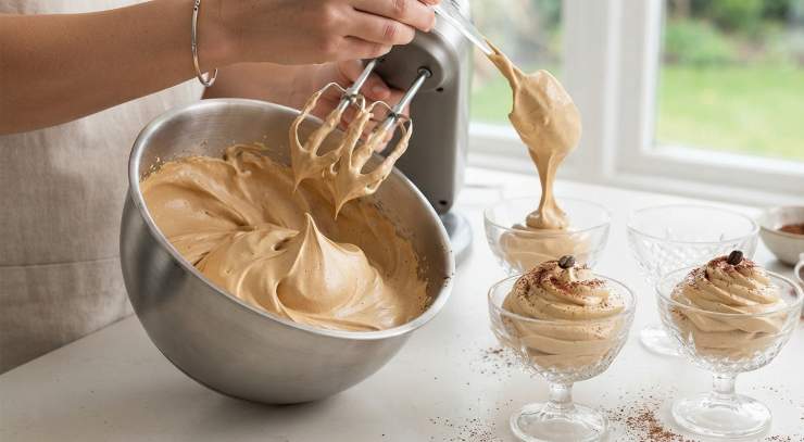 Continuate a lavorare con le fruste fino a quando la consistenza sarà talmente ferma da rimanere salda nella ciotola, esattamente come la classica crema del bar.Distribuite la spumosa crema di caffè in quattro bicchieri o coppette monoporzione. Completate la preparazione spolverizzando la superficie con un leggero velo di cacao amaro prima di servire immediatamente ai tuoi ospiti o di gustarla in totale relax.