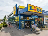 Esterno di un punto vendita Lidl in Italia con clienti, carrelli della spesa e parcheggio gratuito