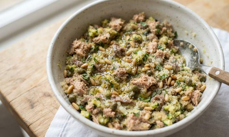 In una padella capiente, scaldate un giro di olio extravergine d’oliva e fate rosolare la cipolla tritata finemente insieme ai filetti di alici sott’olio, che dovranno sciogliersi completamente. Unite nella padella la polpa delle zucchine tritata e i capperi dissalati. Fate cuocere per qualche minuto a fuoco vivace per far evaporare l’acqua in eccesso, poi spegnete il fuoco. Trasferite il composto cotto in una terrina, aggiungete il tonno sott’olio sgocciolato e sminuzzato, il pane ammorbidito e strizzato, i pinoli, il parmigiano grattugiato, la maggiorana e le uova. Regolate di sale e pepe e mescolate energicamente con un cucchiaio fino ad ottenere un ripieno omogeneo e compatto.