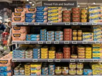 Scaffale di un supermercato con esposizione di diverse confezioni e marche di tonno in scatola