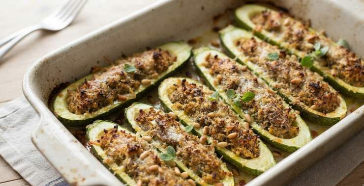 Farcite generosamente ogni guscio di zucchina con il composto preparato, premendo leggermente con le dita affinché il ripieno aderisca perfettamente. Disponete le zucchine così farcite all’interno di una teglia rivestita di carta forno (o unta con un filo d’olio). Completate con un filo d’olio extravergine in superficie. Cuocete in forno statico preriscaldato a 180°C per circa 35-40 minuti, o comunque finché la superficie non risulterà ben dorata e gratinata. Sfornate, lasciate intiepidire leggermente e servite in tavola!