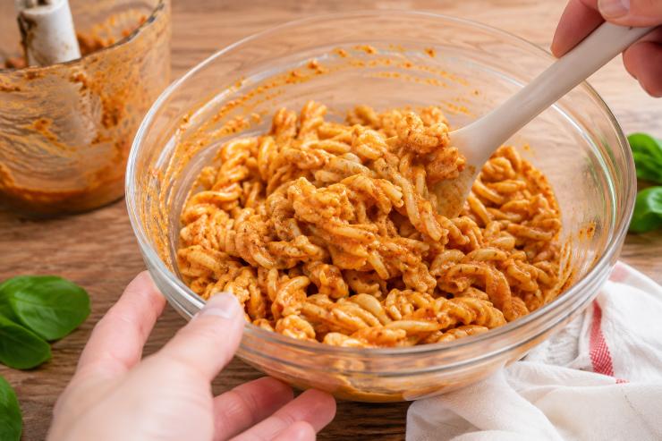 Frullate il tutto aggiungendo, se necessario, uno o due cucchiai di acqua di cottura della pasta, fino a ottenere una crema liscia e densa. Scolate la pasta, raffreddatela velocemente sotto l’acqua corrente (opzionale, per bloccare la cottura) e conditela con il pesto preparato.